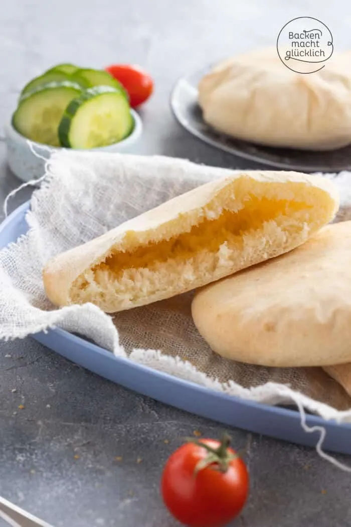 Eine frisch gebackene Pita-Tasche wird vorsichtig geöffnet, um die Füllung zu zeigen