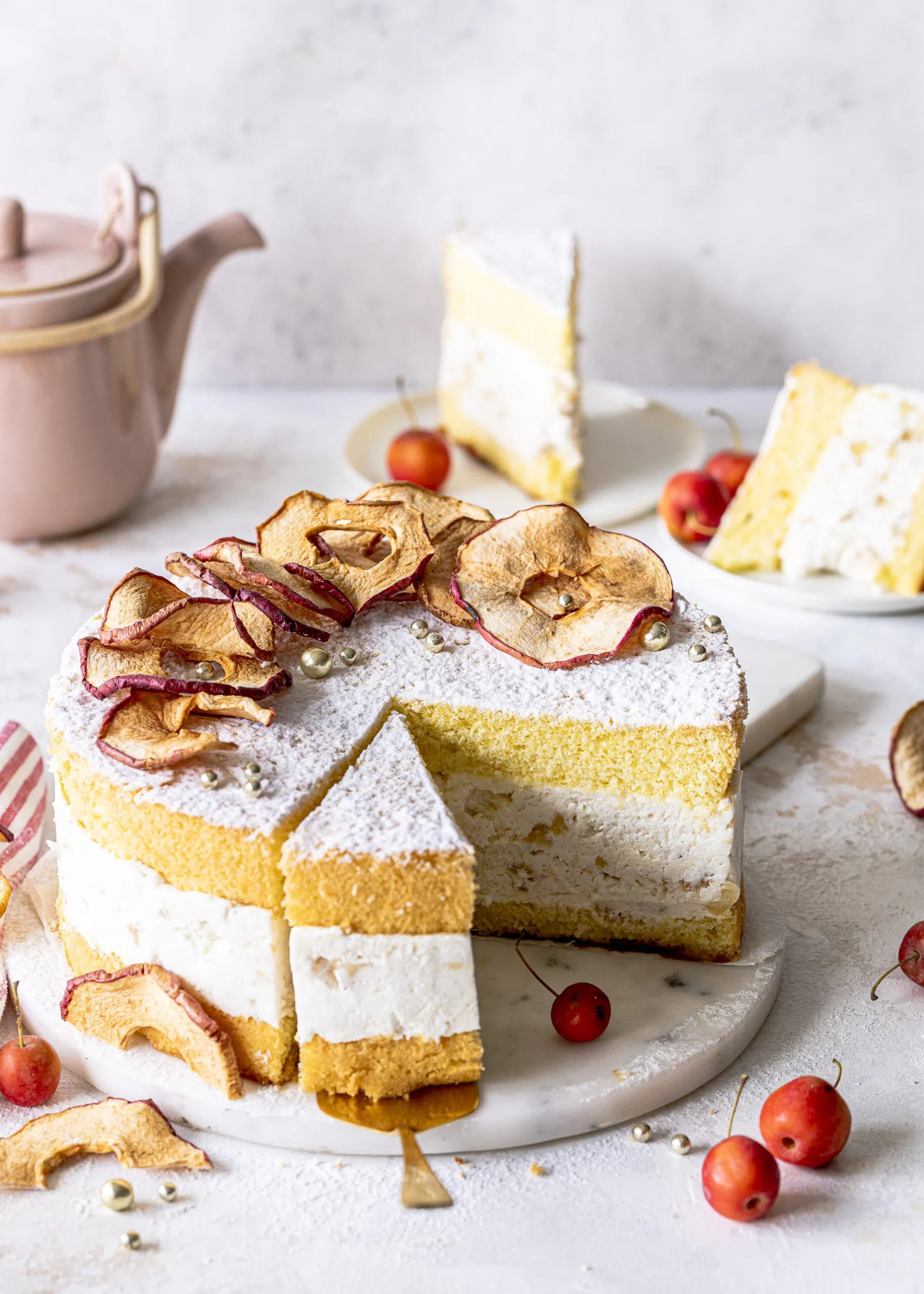 Eine ganze Bratapfel-Käse-Sahne-Torte mit weihnachtlicher Dekoration und Puderzucker.