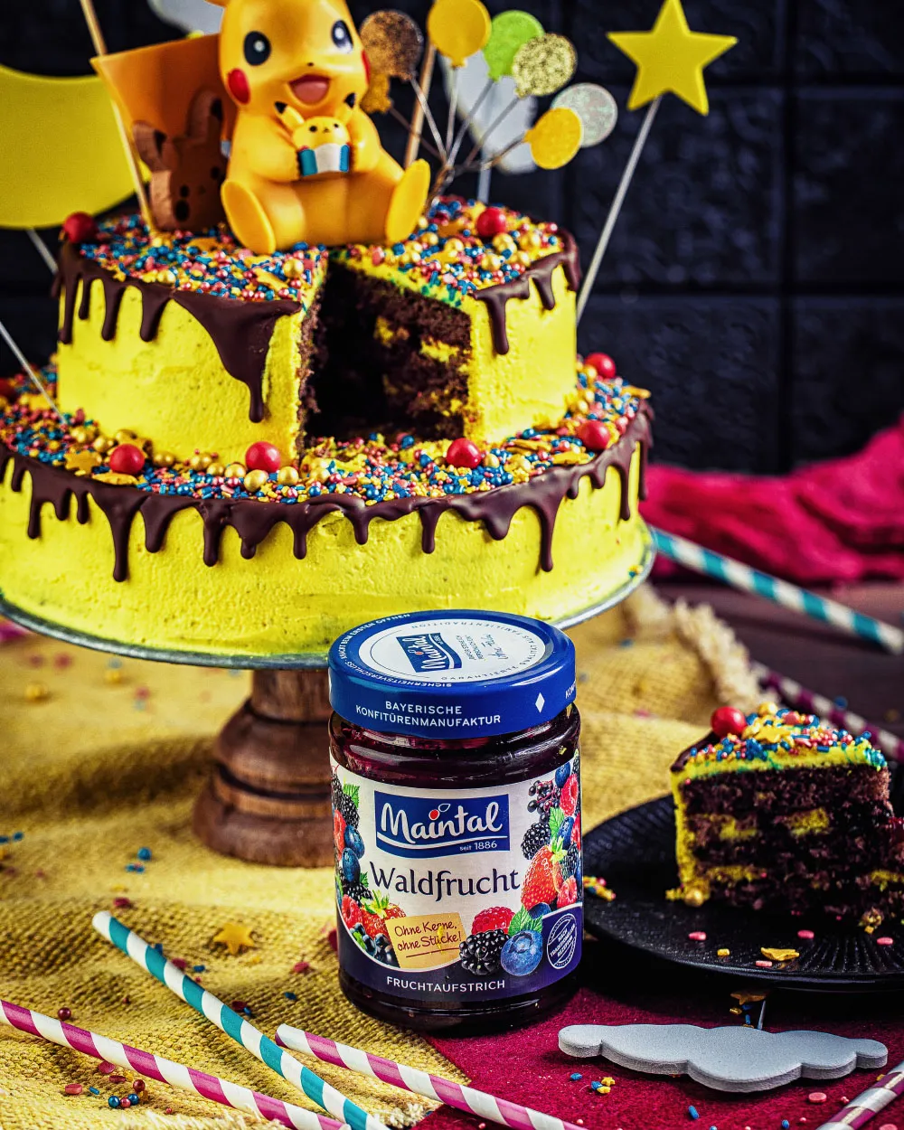 Eine Hand streicht Waldfrucht-Konfitüre auf einen Tortenboden, vorbereitend für die Füllung der Schichttorte