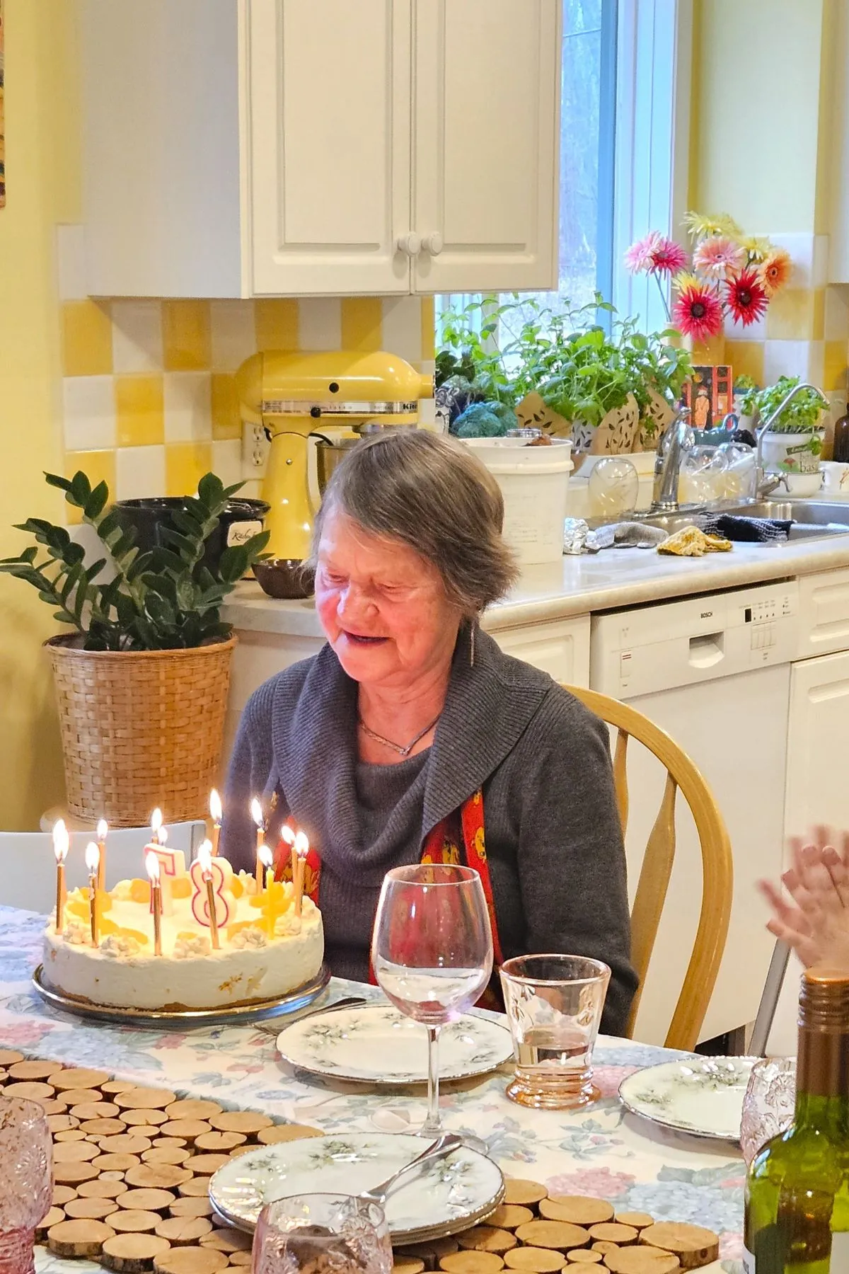 Eine lächelnde Mutter feiert ihren 87. Geburtstag mit einer Mandarinen Sahne Torte.