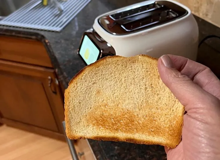 Eine leicht gekrümmte Brotkruste vor dem Toaster. Der Tineco Toasty One konnte diese Seite nicht gleichmäßig toasten.