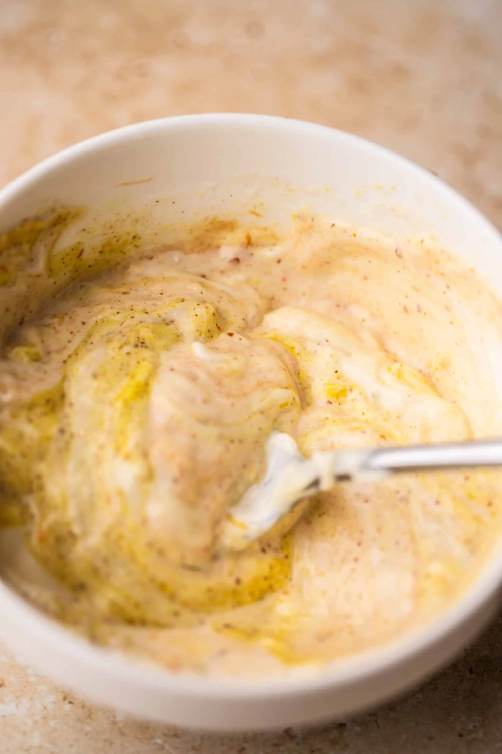 Eine Mischung aus Mayonnaise, Senf und Ketchup wird in einer kleinen Schüssel mit einem Löffel vermischt.