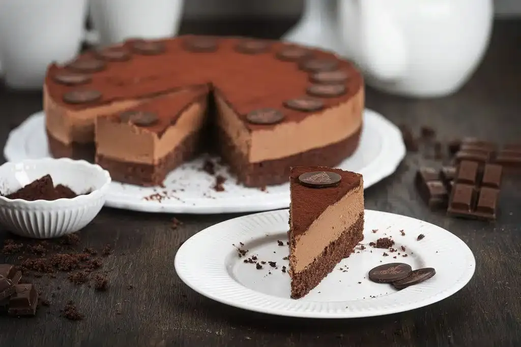 Eine Nahaufnahme der dunklen Schokoladenganache, die für die Torte verwendet wird, in einem Topf.