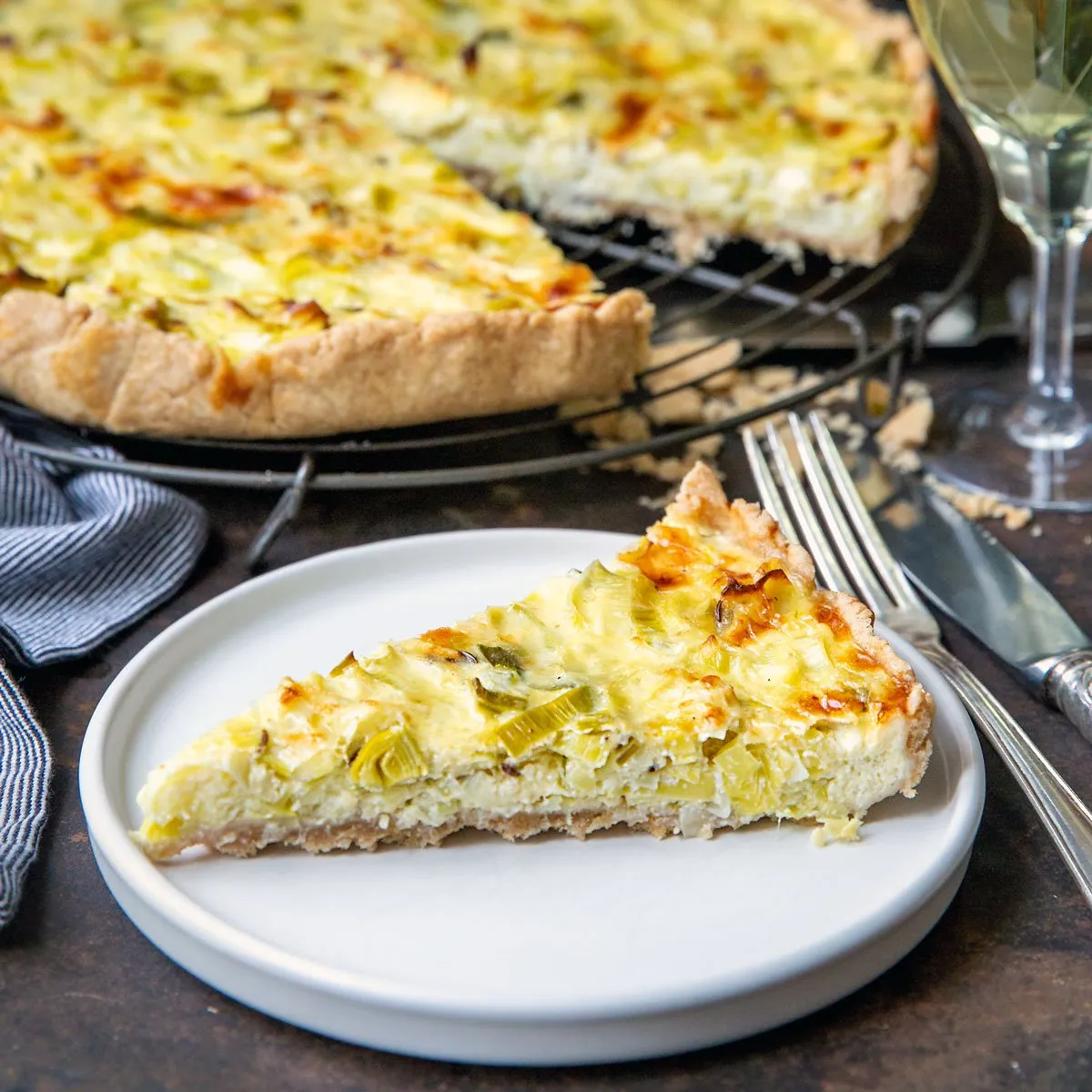 Eine Nahaufnahme der goldbraunen Kruste einer gebackenen Lauch Quiche