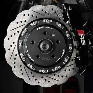 Eine Nahaufnahme einer Hochleistungsbremsanlage mit Bremssattel und gelochter Bremsscheibe