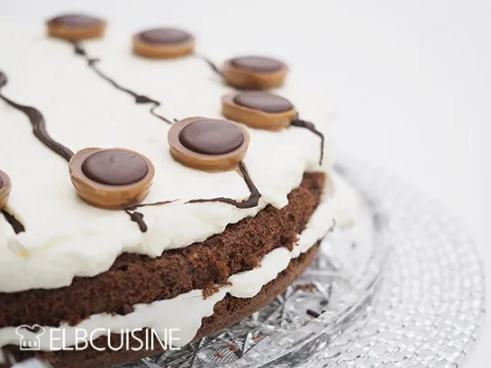 Eine Nahaufnahme eines angeschnittenen Naked Cakes, der die Schichten von Kuchen, Sahne und Toffifee offenbart