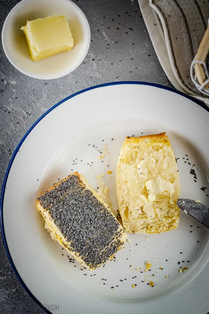 Eine Nahaufnahme von Birkes, die im Ofen gebacken werden, mit sichtbarem Mohnbelag.