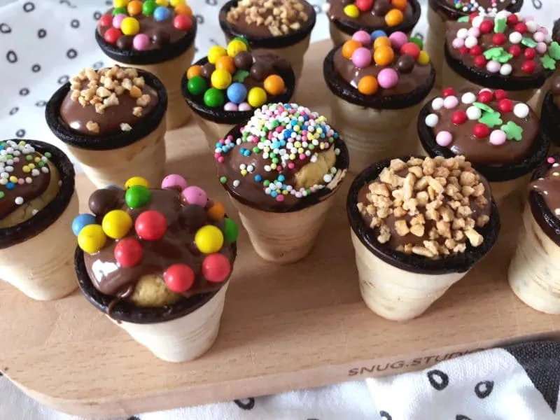 Eine Nahaufnahme von bunten Waffelmuffins, verziert mit Schokolade und Streuseln, bereit zum Servieren