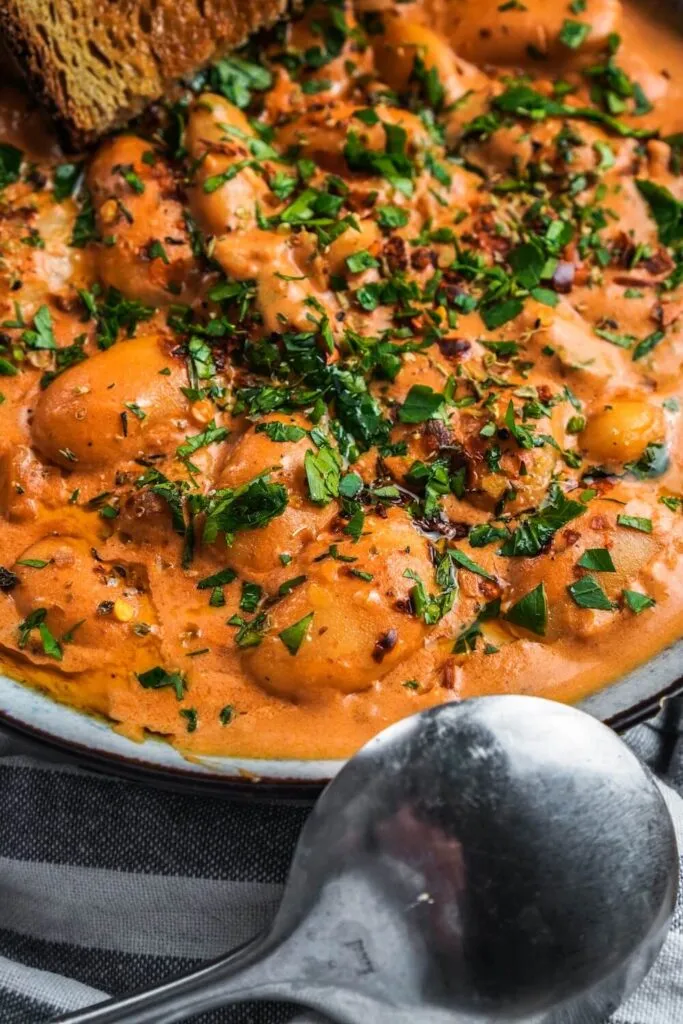 Eine Nahaufnahme von dicken Bohnen in einer würzigen Tomatensoße, serviert in einer Schale