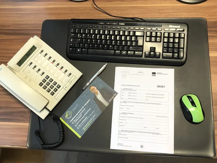 Eine Nahaufnahme von Händen, die ein Formular ausfüllen, das mit "Antrag" überschrieben ist.