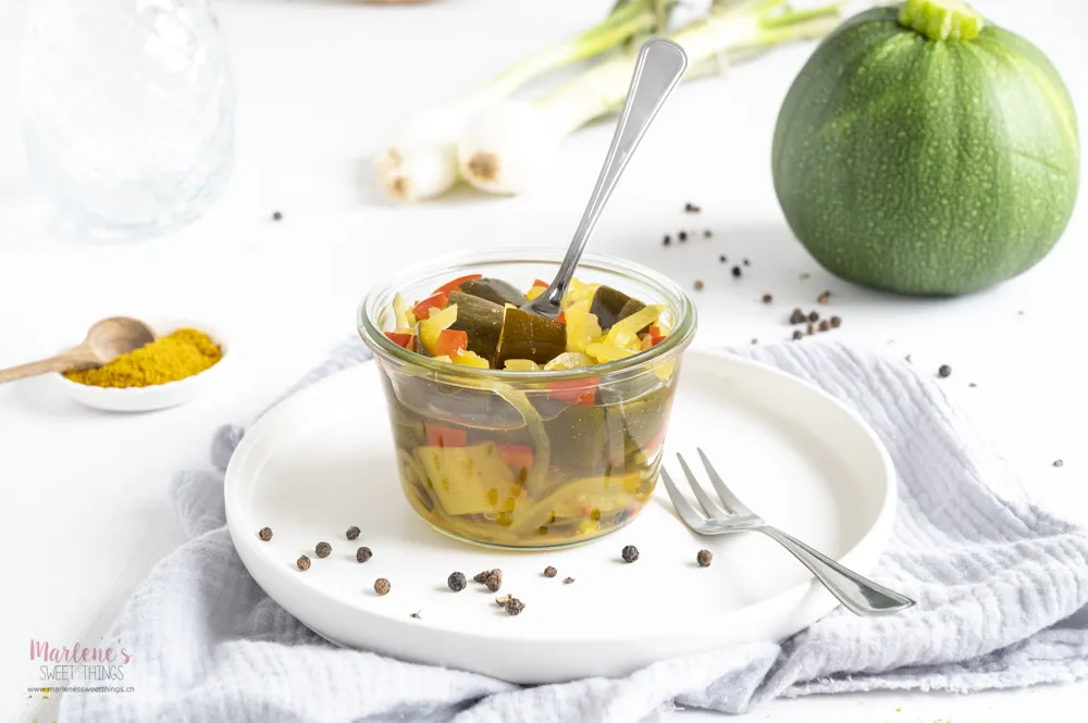 Eine Nahaufnahme von süss-sauren Curry-Zucchetti im Glas