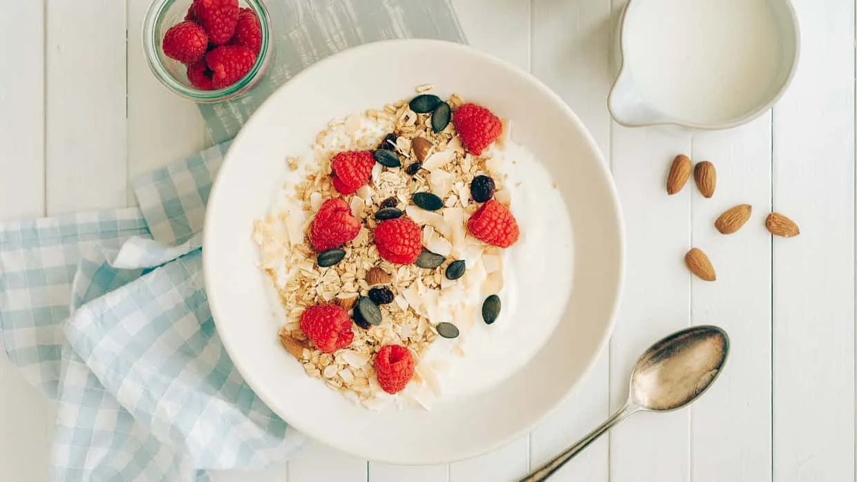 Eine nahrhafte Schüssel mit Joghurt, ballaststoffreichen Haferflocken und frischen Beeren für ein gesundes Frühstück.