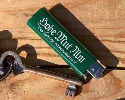 Eine Person erwärmt einen Haustürschlüssel mit einem Feuerzeug, um ihn als alternative Wärmebehandlung bei einem Bienenstich zu nutzen