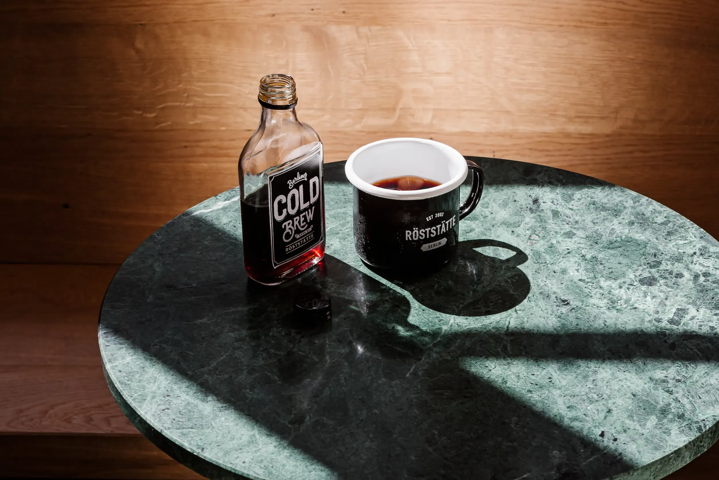 Eine Person hält eine Tasse Cold Brew Konzentrat in der Hand, mit Fokus auf die cremige Textur des Getränks