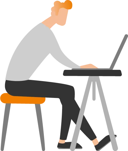 Eine Person sitzt am Schreibtisch und arbeitet konzentriert an einem Laptop.