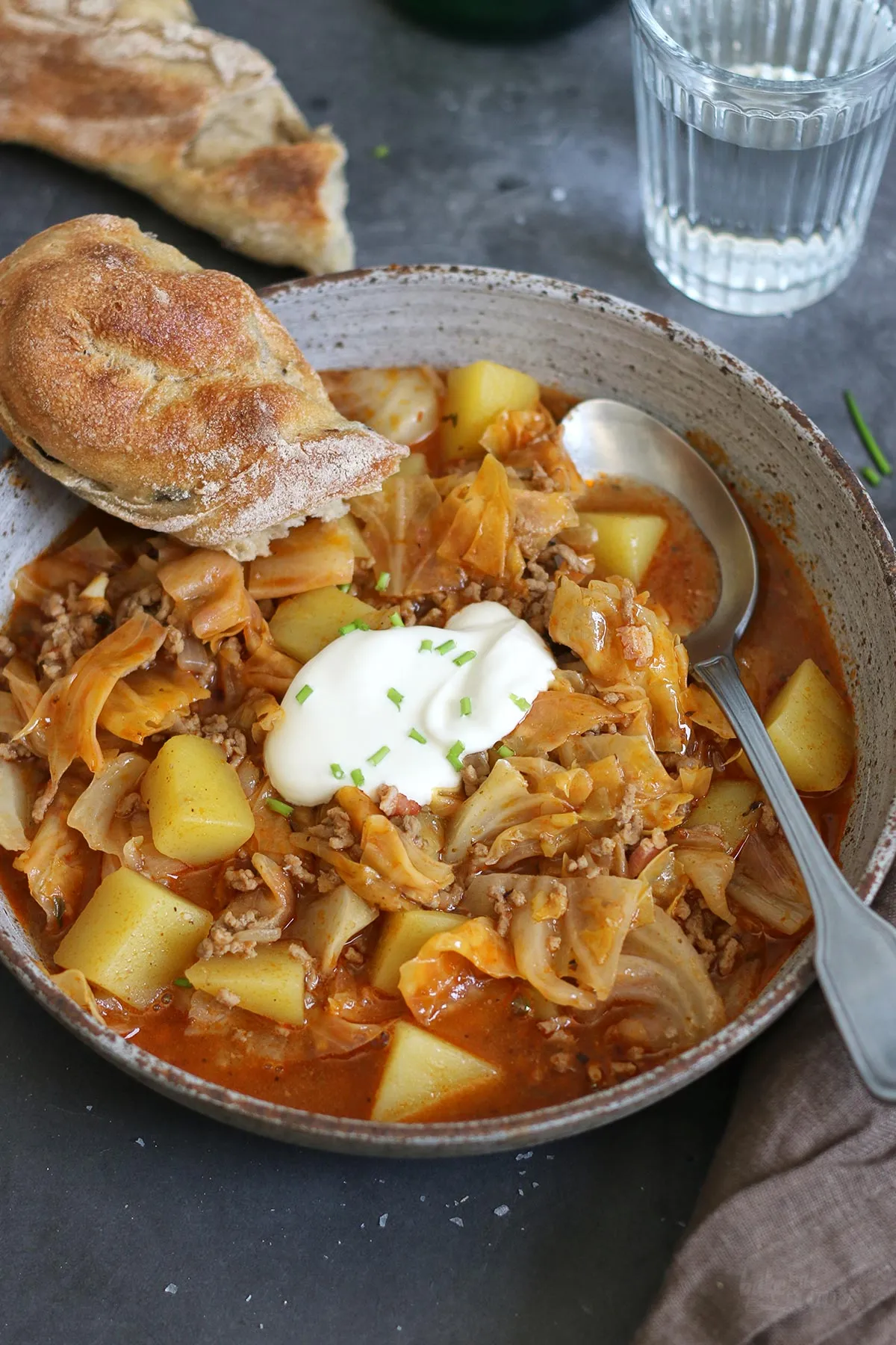 Eine Portion Schichtkohl in einer rustikalen Schale, garniert mit Schmand und Kräutern