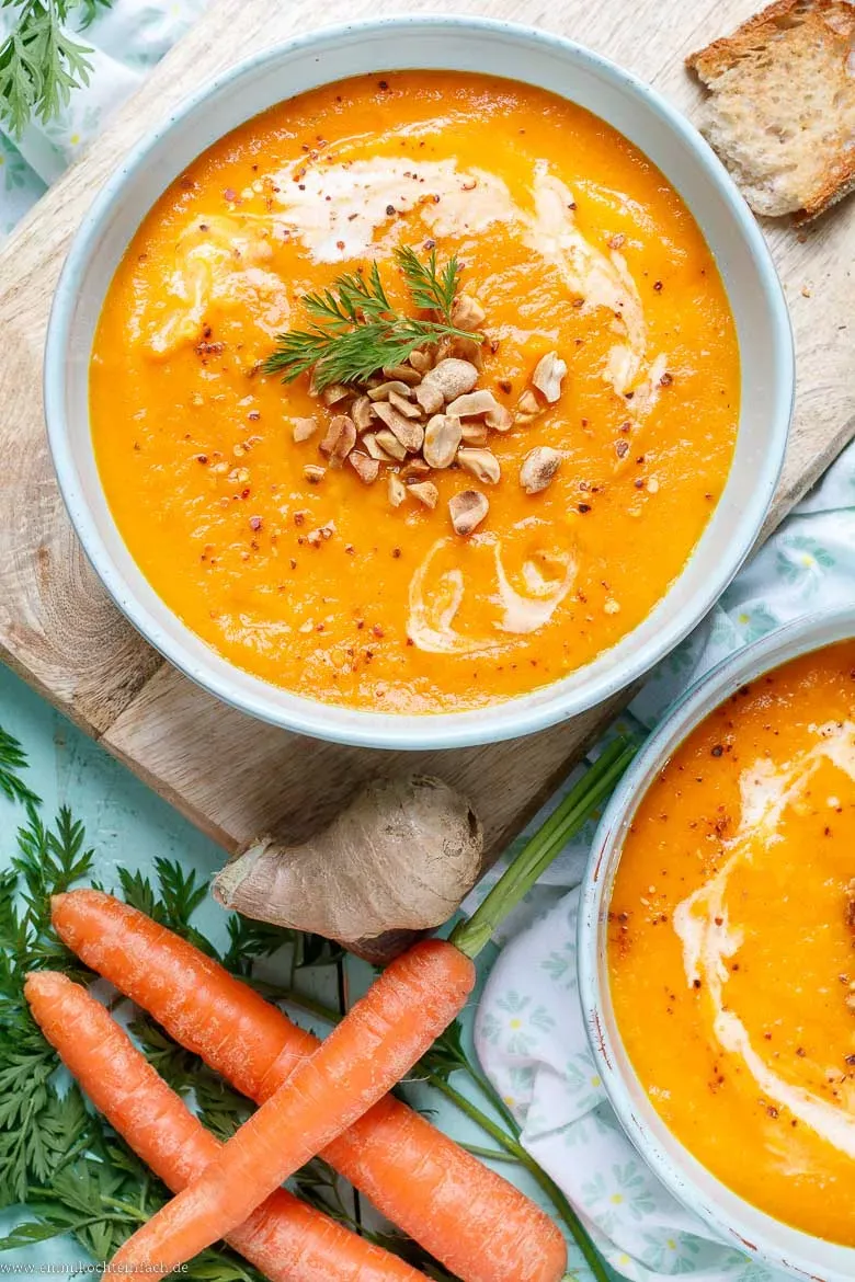 Eine reichhaltige und cremige Möhrensuppe mit frischen Kräutern garniert in einer modernen Schüssel