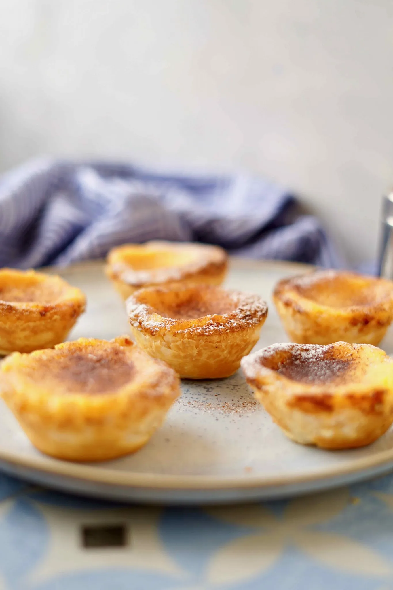 Eine Reihe von Pastéis de Nata, die auf einem Gitter abkühlen