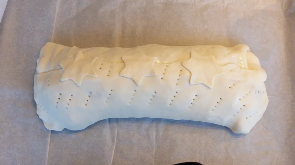 Eine Rolle Blätterteig wird auf der Arbeitsfläche für die Zubereitung ausgebreitet