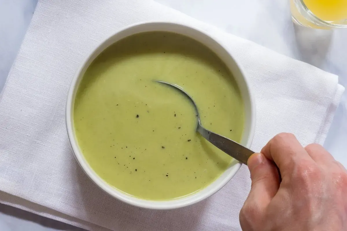 Eine Schale frisch zubereiteter, cremiger Zucchinisuppe mit Garnitur