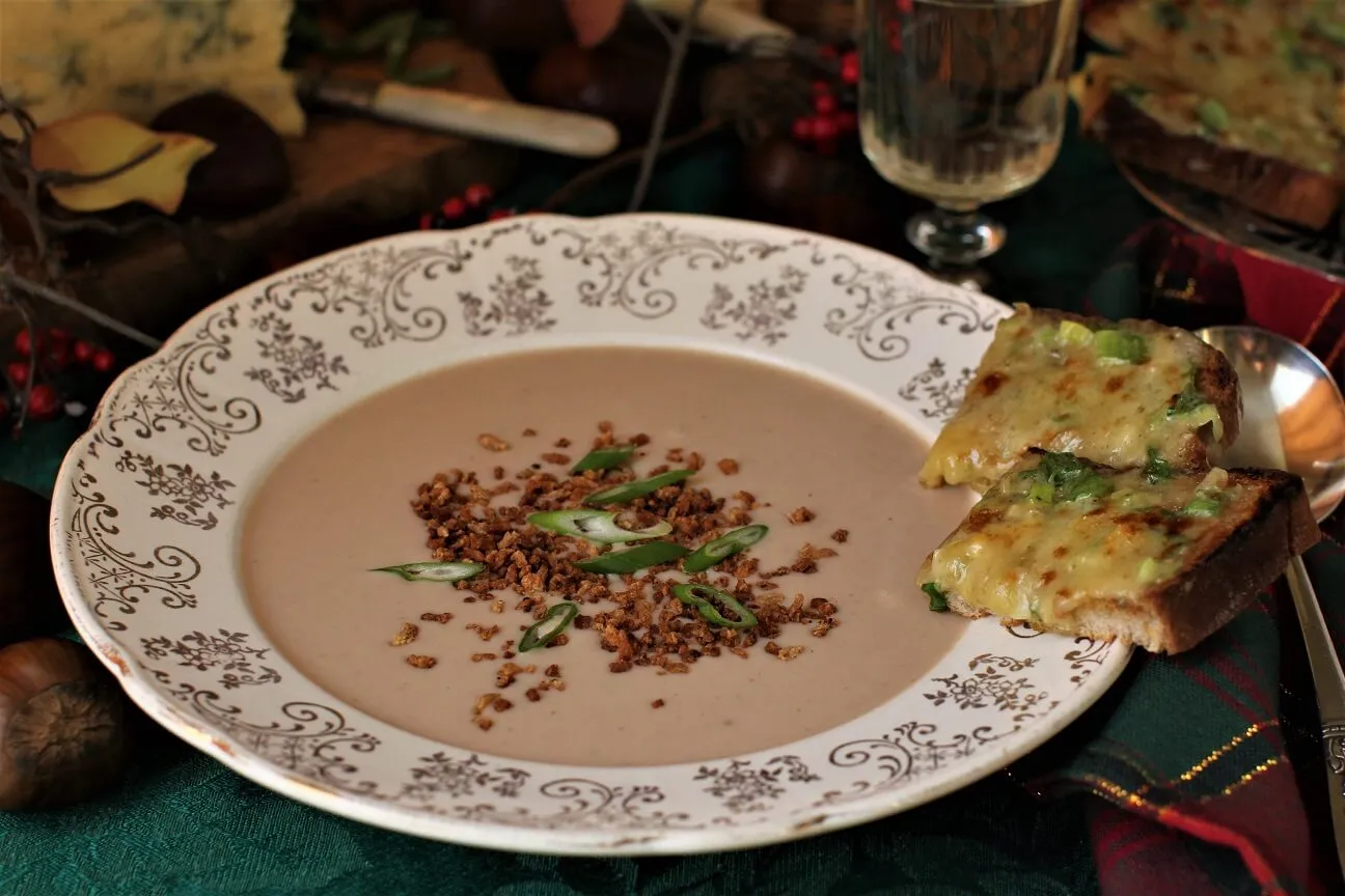 Eine Schüssel Maronensuppe mit zwei Stilton-Toasts am Rand, appetitlich angerichtet