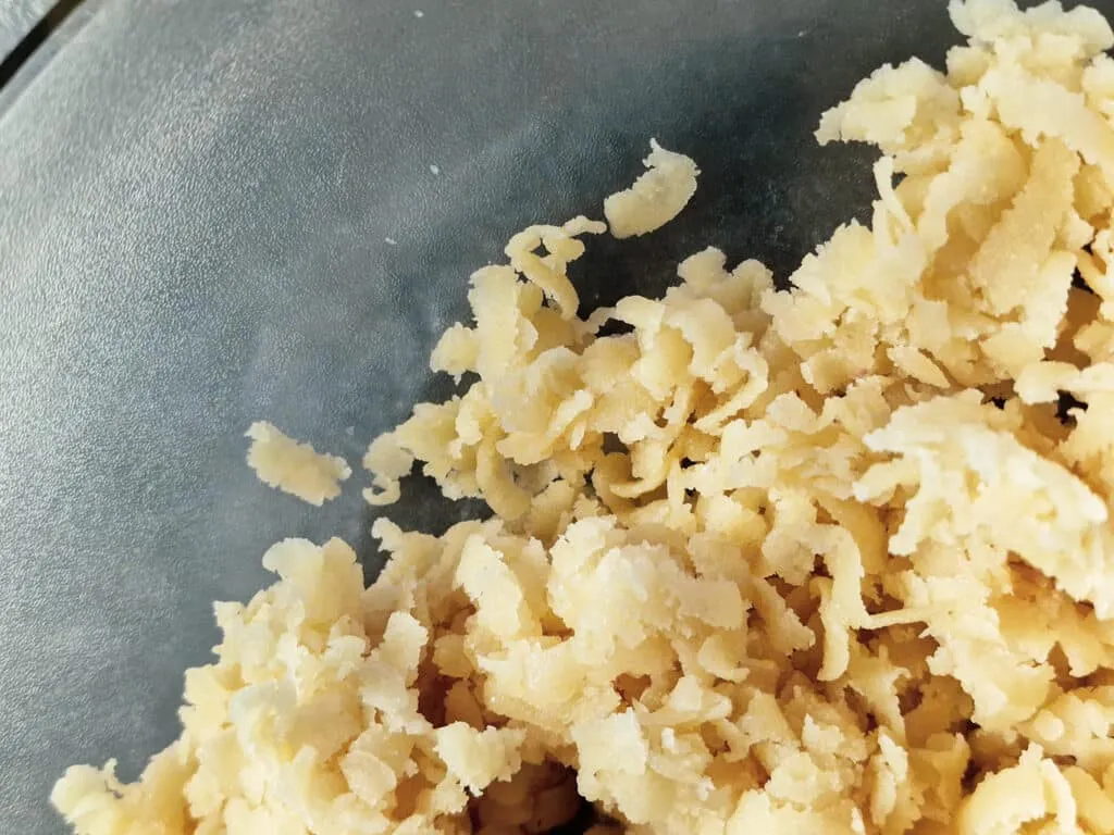 Eine Schüssel mit geriebenem Marzipan, bereit, mit weiteren Zutaten zu einem köstlichen Kuchenteig verarbeitet zu werden