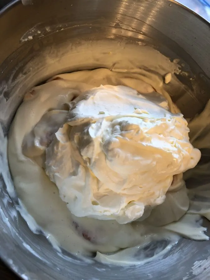 Eine Spekulatius Sahne Torte wird mit geschlagener Sahne und gehobelten Mandeln verziert.