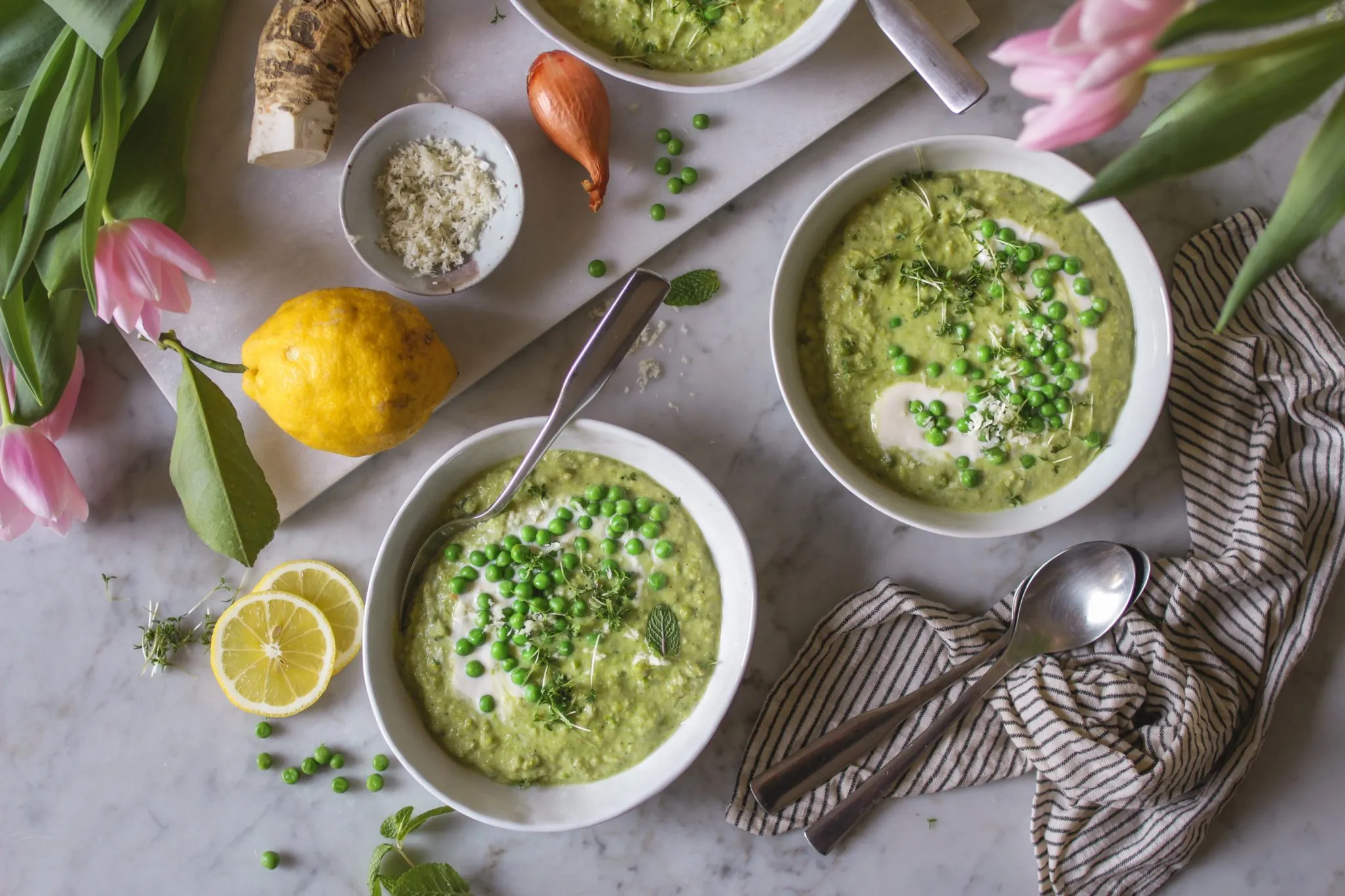 Eine weitere Ansicht der fertig angerichteten Erbsen-Kokossuppe mit frischen Kräutern und Sprossen