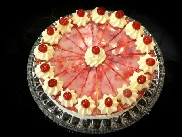 Eine wunderschön dekorierte Holländische Sahnetorte mit Sahnerosetten und kandierten Kirschen