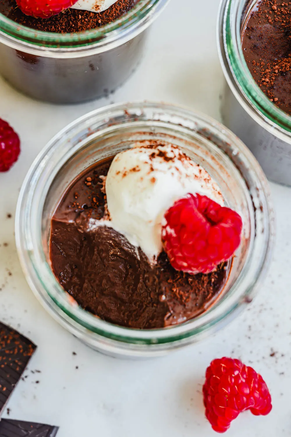 Einfacher Schokopudding in kleinen Glasschälchen, verziert mit frischen Beeren und Minze