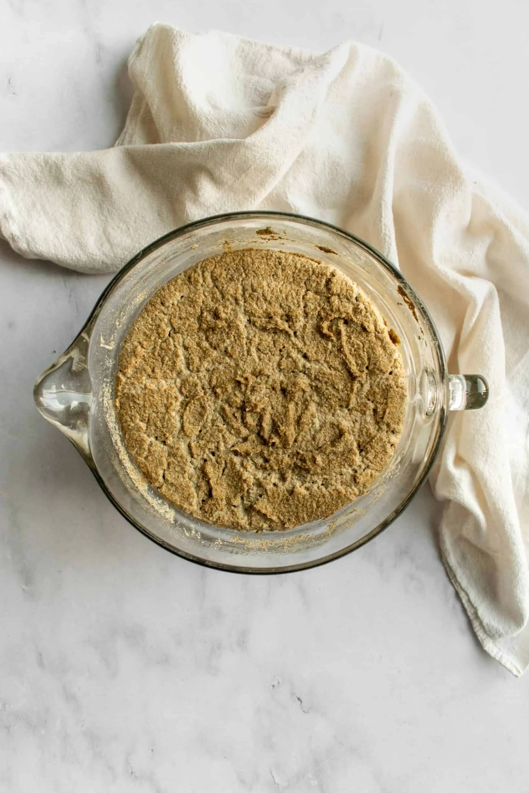 Eingeweichtes und aufgegangenes Roggenmehl-Sauerteig-Gemisch in Glasschüssel.