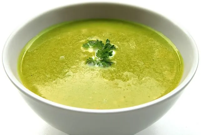 Erfrischende, grüne Erbsensuppe in einer weißen Schale, perfekt für heiße Sommertage