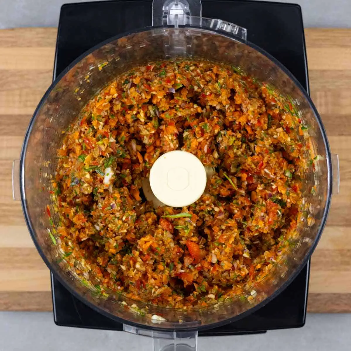 Fein gehacktes Gemüse und Kräuter in einer Küchenmaschine.