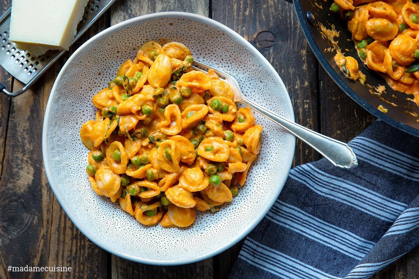 Fertig angerichtete Pasta mit Erbsen und Tomatensugo auf einem Teller