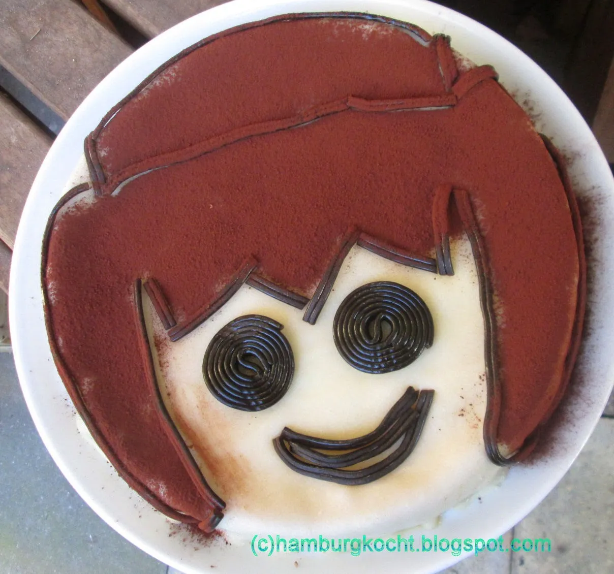 Fertig dekorierter Playmobil-Kuchen mit Lakritz-Konturen und Kakao-Haaren