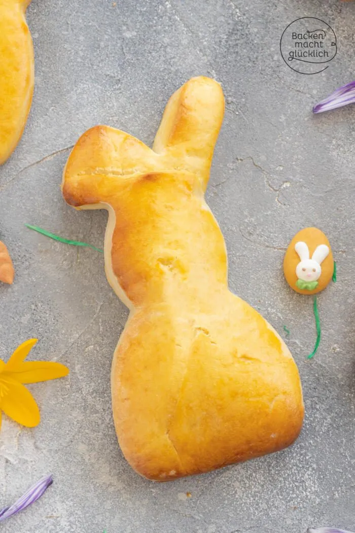 Fertig gebackene, goldbraune Osterhasen aus Hefeteig auf einem Gitterrost