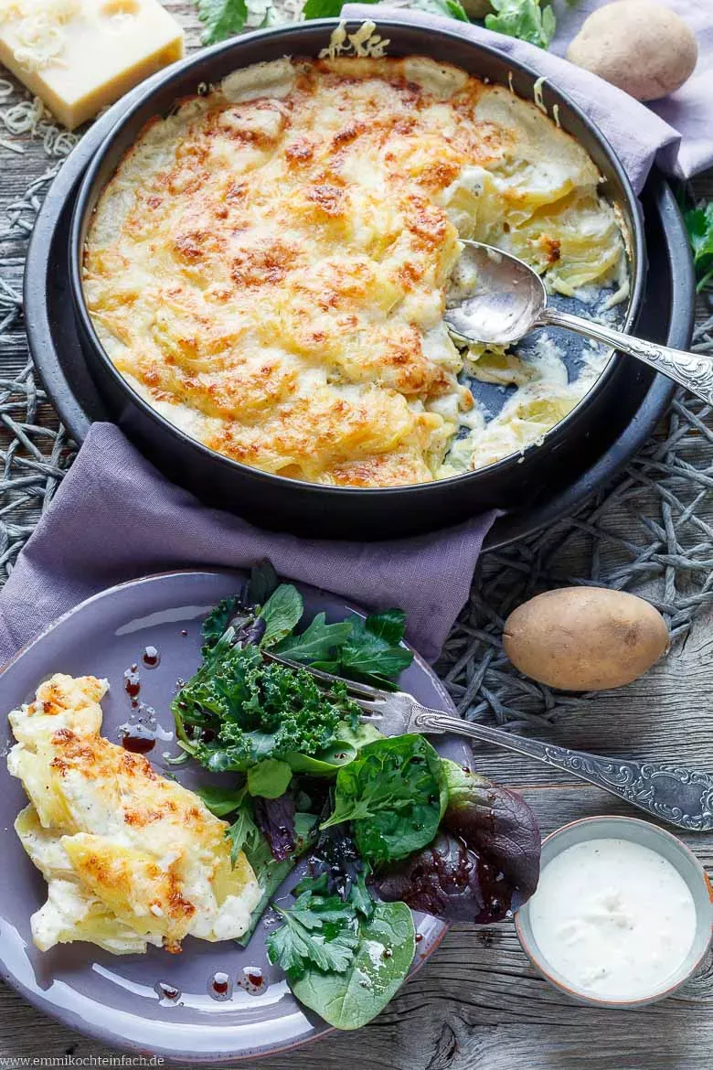 Fertig gebackenes Kartoffelgratin als Beilage mit einem frischen grünen Salat