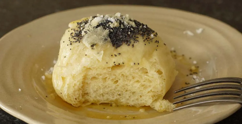 Fertig geformte Hefeklöße, die auf einem bemehlten Brett ruhen und aufgehen