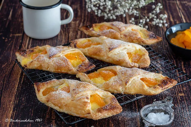 Fertige süße Blätterteigschiffchen mit Puderzucker bestäubt