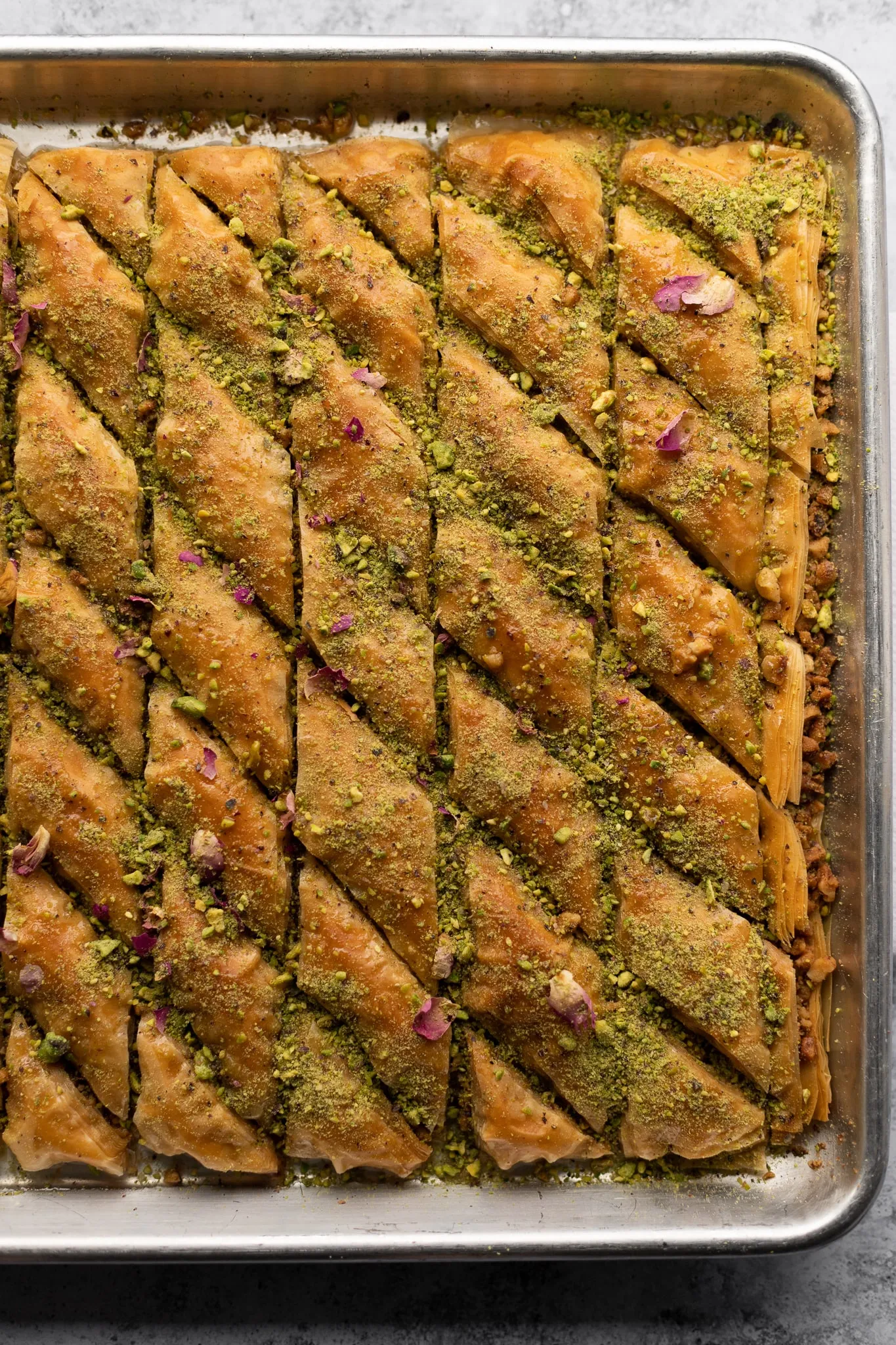 Fertiges veganes Baklava, bedeckt mit Pistazien und Rosenblüten, bereit zum Servieren