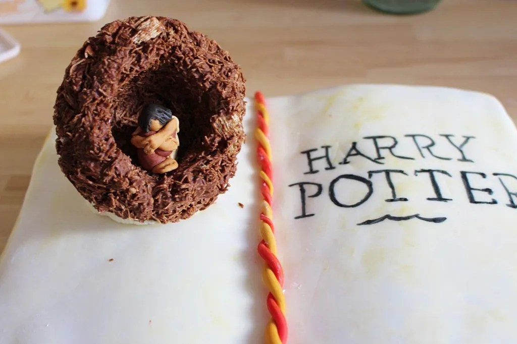 Finale Dekoration: Figur im Nest mit Buttercreme befestigen und Nest auf das Buch kleben