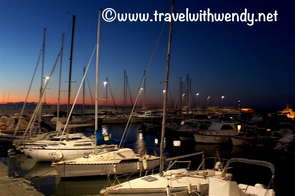 Frau, die sich überrascht umschaut, vor einer malerischen italienischen Küstenstadt