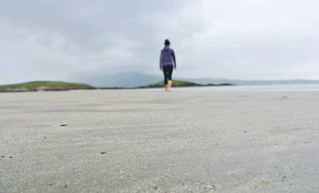 Frau fährt mit dem Mietwagen durch die malerische Landschaft Irlands entlang der Küste