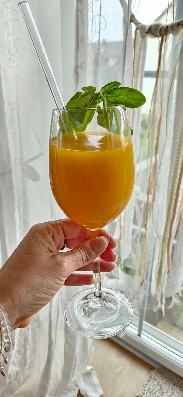 Frau trinkt RINGANA BTY Beauty-Drink mit Eis im Glas