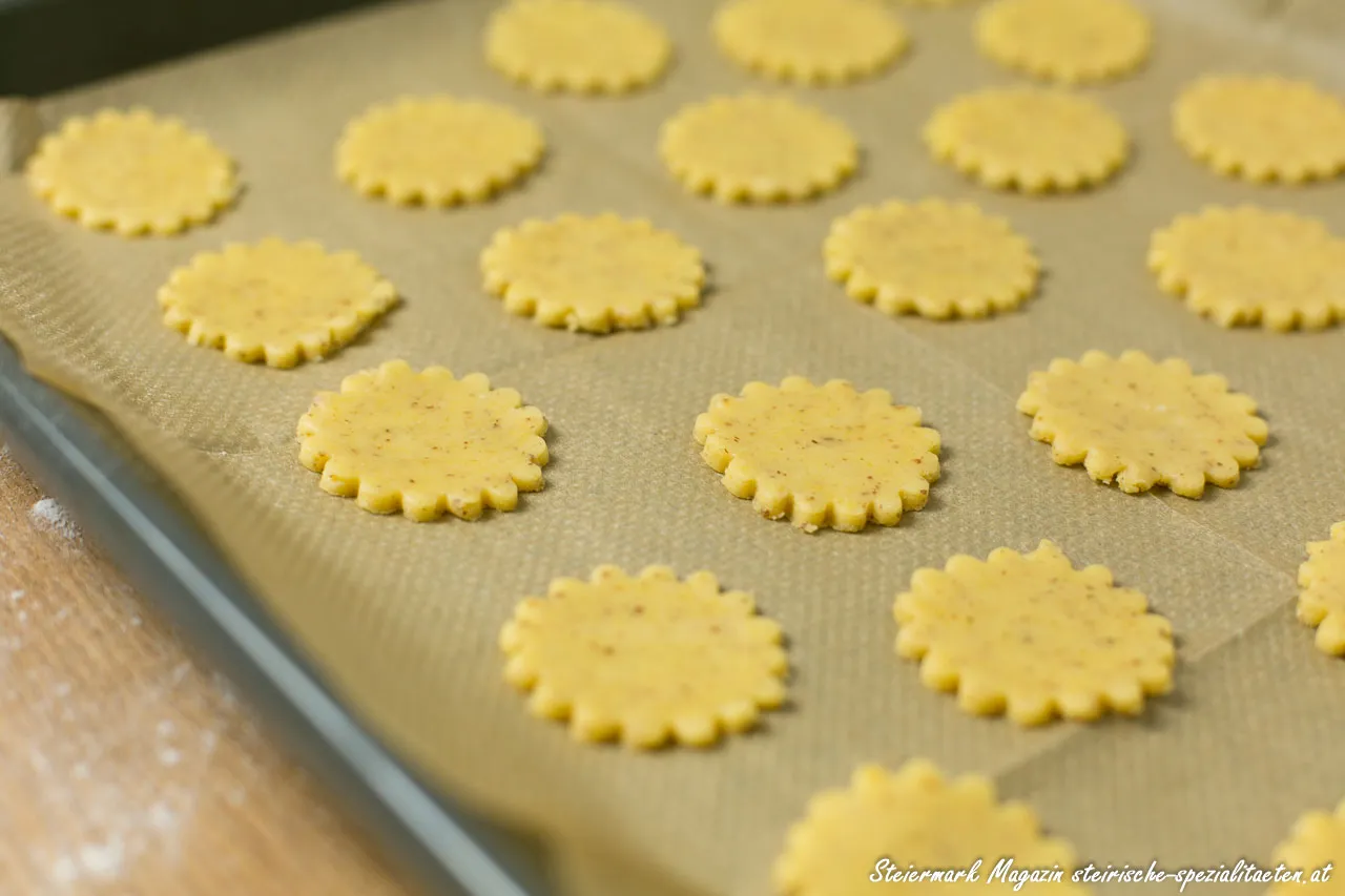 Frisch gebackene Linzer Augen Kekse auf einem Backblech, bereit zum Füllen