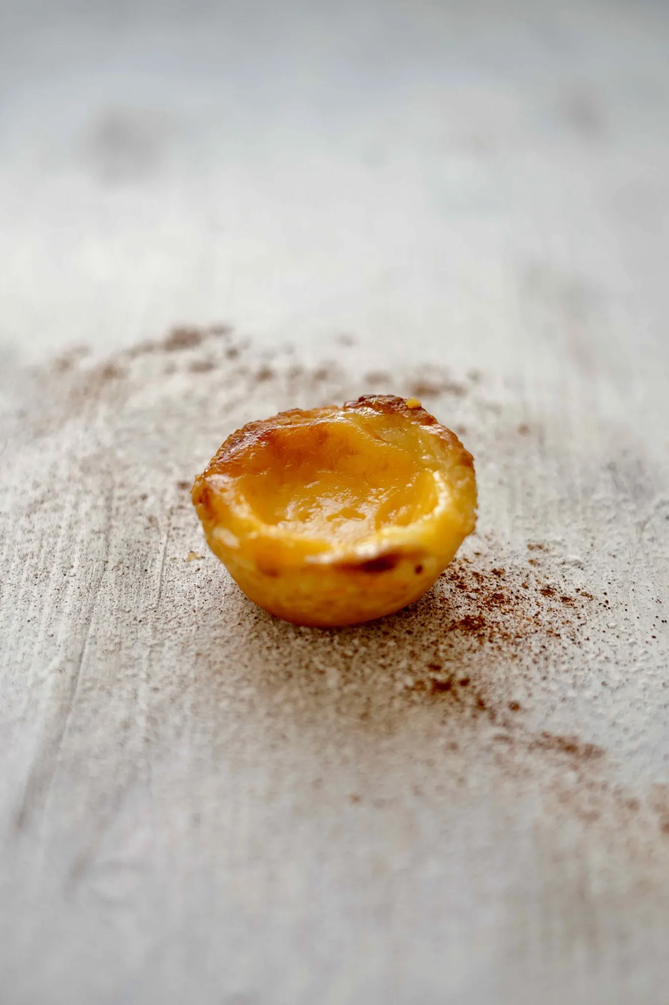 Frisch gebackene Pastéis de Nata mit Zimt und Puderzucker bestreut