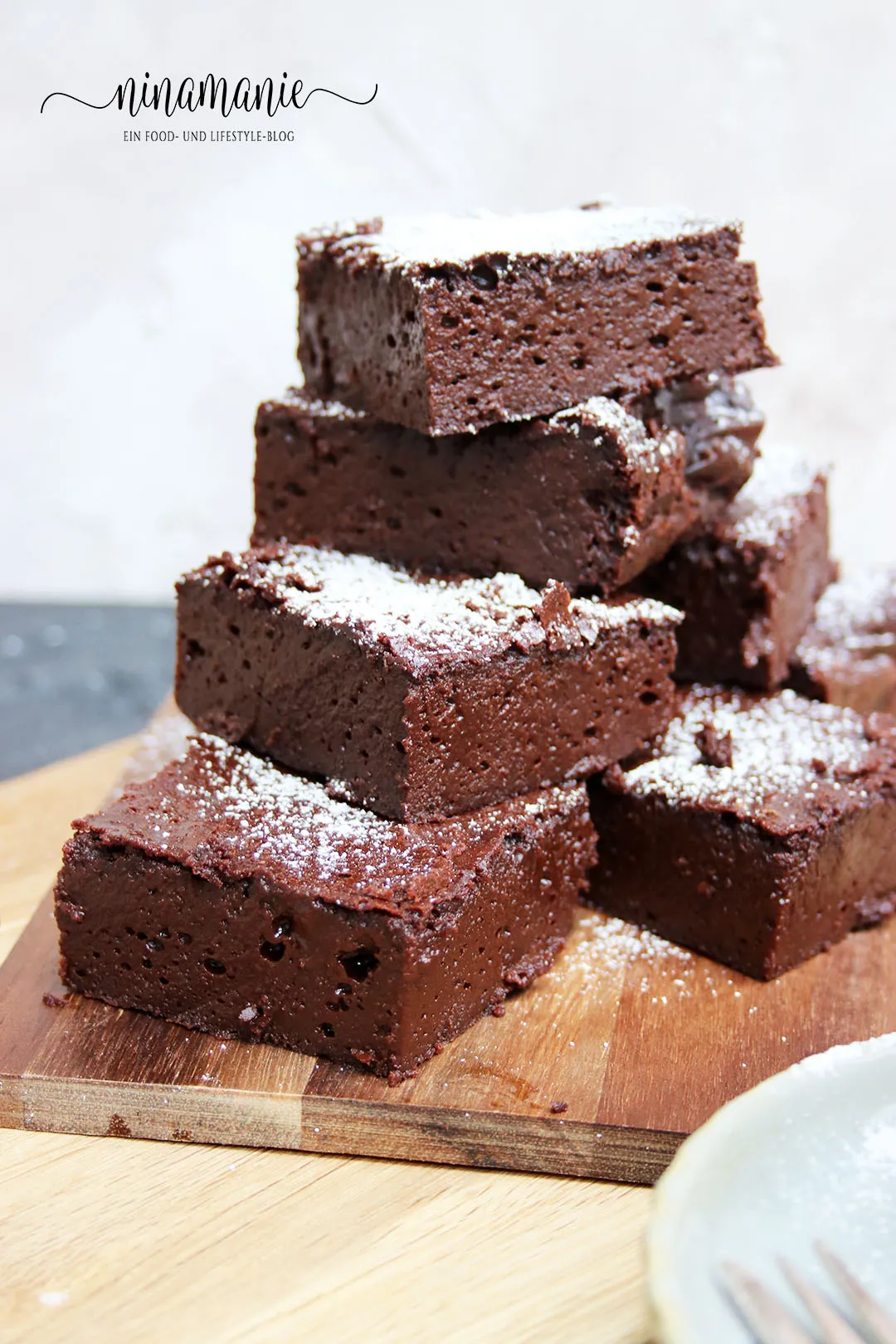 Frisch gebackene, saftige glutenfreie Brownies mit Puderzucker bestreut