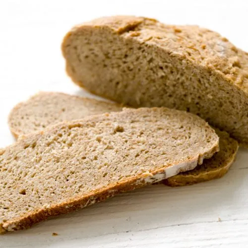 Frisch gebackenes Brot in Scheiben auf einem Holzbrett