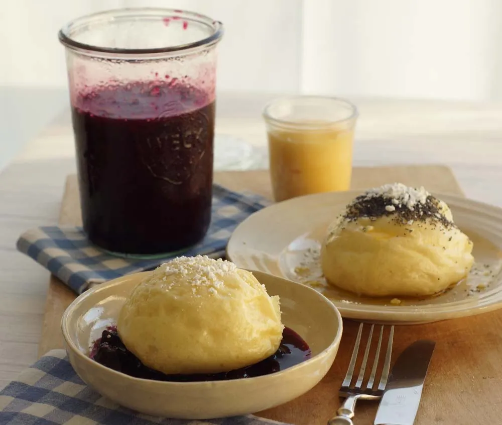 Frisch gedämpfte Hefeklöße ruhen auf einem Geschirrtuch über einem Topf, bereit zum Servieren