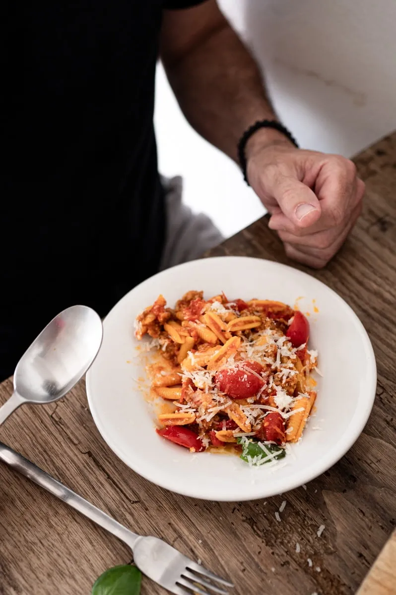 Frisch gekochte Malloreddus werden in eine Pfanne mit Salsiccia-Tomatensauce gegeben